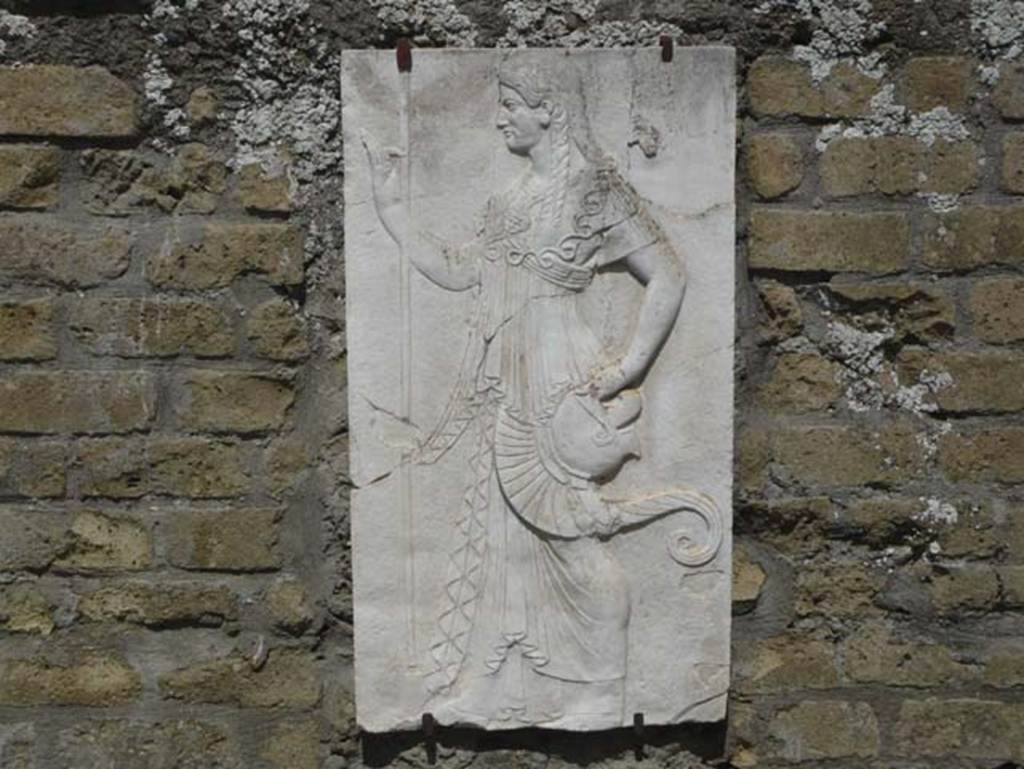 Herculaneum, August 2013. Sacred Area terrace, the shrine of Four Gods. Reproduction relief of Minerva. Photo courtesy of Buzz Ferebee.